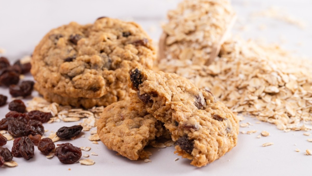 Multiple sugar-free oatmeal cookies with yogurt and raisins. Ingredients are also visible.