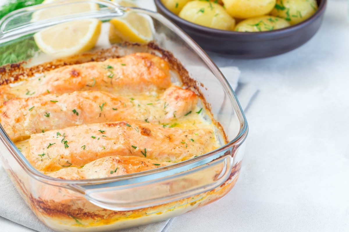 Baking dish with salmon gratin on a light background
